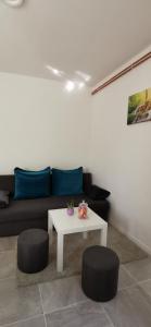 a living room with a couch and a table and two stools at APARTMAN DEDA in Rakovica