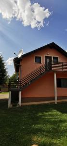 a house with a balcony on the side of it at APARTMAN DEDA in Rakovica
