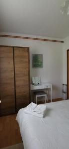 a bedroom with a white bed and a desk at APARTMAN DEDA in Rakovica