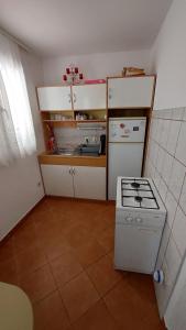 eine kleine Küche mit einem Herd und einem Kühlschrank in der Unterkunft Apartment Oaza in Rogoznica