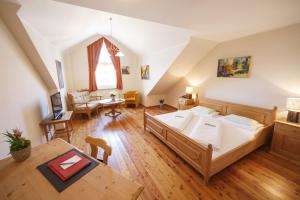 Cette grande chambre comprend un lit et une table. dans l'établissement Il Plonner - Hotel Restaurant Biergarten, à Weßling