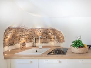 una cucina con lavandino e parete in pietra di Dreamers Sea View a Manarola