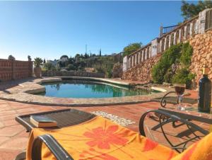 una piscina en un patio con mesa y sillas en Casa Las Piedras, en Frigiliana
