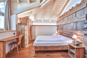 - une chambre avec un lit et un bureau dans l'établissement Garni Maso San Michele, à Cavalese