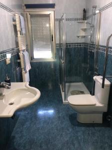 La salle de bains est pourvue d'un lavabo, de toilettes et d'une douche. dans l'établissement HOSTAL CAMELOT, à Fabero