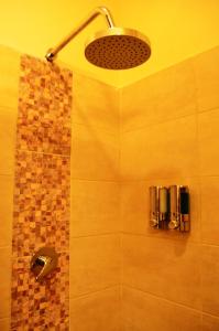 y baño con ducha con cabezal de ducha. en Club del Campo - Hotel & Centro de Convenciones, en Santo Domingo de los Colorados