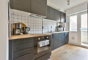 een keuken met roestvrijstalen apparatuur en grijze kasten bij Appart Hypercentre in Lille