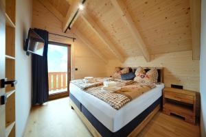 una camera da letto con un grande letto in una camera in legno di Almchalet Hüttenzauber a Klippitztorl