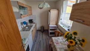 a kitchen with a table with a vase of sunflowers on it at Bauernstübchen in Below