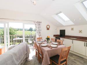 a kitchen and dining room with a table and chairs at The Cider Shed in Winscombe