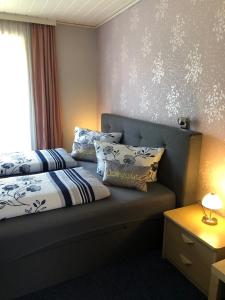 a bedroom with two beds with pillows and a window at Pension Check In in Güstrow