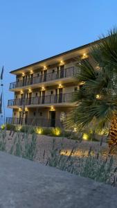 a hotel on the beach with a palm tree in front of it at eleven views resort in Ilia