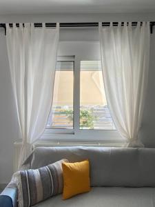 a couch in a living room with a window at Thrace Village - LUXURY APARTMENTS XANTHI (LAX) in Kimméria