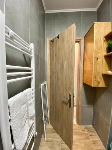 een badkamer met een houten deur in een kamer bij Thrace Village - LUXURY APARTMENTS XANTHI (LAX) in Kimméria
