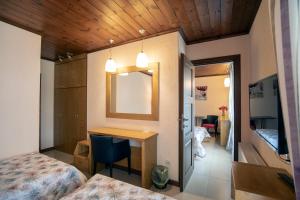 a room with a bed and a desk and a mirror at Asimina Guesthouse, Eptalofos Mount Charm in Eptalofos