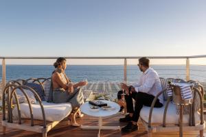 a man and woman sitting on the deck of a cruise ship at Grand Hotel Principe Di Piemonte in Viareggio
