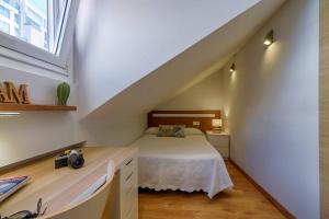 Schlafzimmer im Dachgeschoss mit einem Bett und einem Fenster in der Unterkunft Orzan Beach 2 by TheBlueWaveApartments com in A Coruña