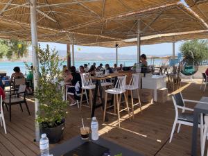 a group of people sitting at tables in a restaurant at Coralli Rooms & Restaurant in Elafonisos