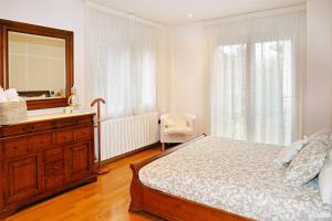 a bedroom with a bed and a dresser and a mirror at Casa Escardill in La Seu d'Urgell