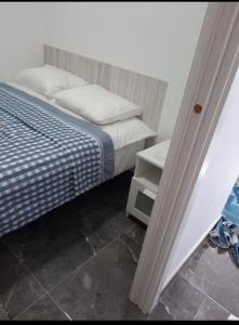 ein Schlafzimmer mit einem Bett mit einer blauen und weißen Decke in der Unterkunft studio for rent in torremolinos -Málaga for vacations studio alquiler para vacationes, studio te huur voor vacantie Calle Río Mesa 5 in Torremolinos