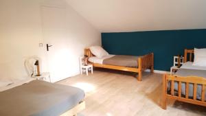 1 dormitorio con 2 camas y pared azul en La Grange du Héron, en Balaguier-dʼOlt