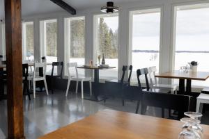 a dining room with tables and chairs and windows at Kipinä Lomat - Majatalo Kipinä in Sotkamo