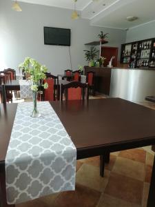 uma mesa de jantar com um vaso de flores em Hotel Fregata em Pęczniew