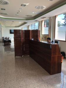 a man sitting at a reception desk in a building at Hotel Segontia in Épila