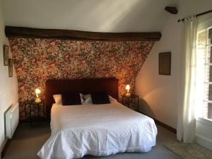 ein Schlafzimmer mit einem großen weißen Bett mit Ziegelwand in der Unterkunft Le Moulin de l`Epinay in Sainte-Beuve-en-Rivière