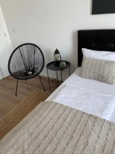 um quarto com uma cama grande e uma cadeira em SOLE Apartment 2 em Satu Mare