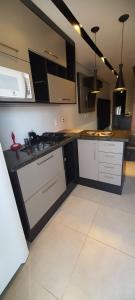 a kitchen with black and white cabinets and a sink at New York City Village - Barão Geraldo - Campinas in Campinas