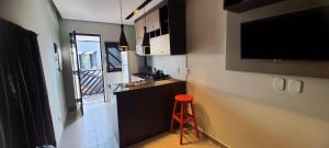 uma pequena cozinha com um banco vermelho num quarto em New York City Village - Barão Geraldo - Campinas em Campinas