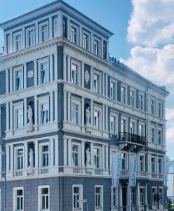 - un grand bâtiment blanc avec statues dans l'établissement A&F Hotel Chemnitz, à Chemnitz