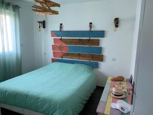 a bedroom with a bed and a table with a hat at Maison moderne à Cheval-Blanc in Cheval-Blanc
