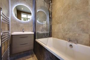 a bathroom with a tub and a sink and a mirror at Large En-suite by the Beach in Bournemouth