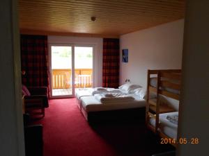 a hotel room with two beds and a balcony at Pension Da Capo in Sankt Georgen ob Murau