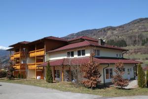 a large house with a mountain in the background at Pension Da Capo in Sankt Georgen ob Murau