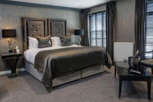 a bedroom with a large bed and a table at The Bold Hotel; BW Signature Collection in Southport