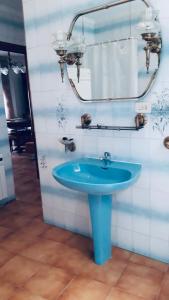 y baño con lavabo azul y espejo. en Casa centro Enguidanos, en Enguídanos