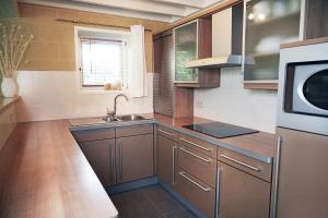 a kitchen with wooden cabinets and a sink and a microwave at Le Vieux Sart 6 Coo Spa Francorchamps in Stavelot