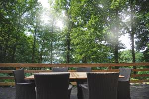 a wooden table and chairs with trees in the background at Le Vieux Sart 6 Coo Spa Francorchamps in Stavelot