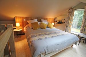 a bedroom with a large bed and a window at LA PETITE CHARMILLE in Châteauponsac