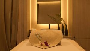 a white towel with flowers on top of a bed at Crowne Plaza Limassol by IHG in Limassol