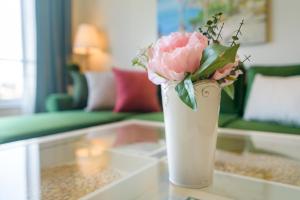 a vase with a pink flower sitting on a table at Apartment A'MORE in St. St. Constantine and Helena