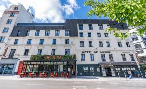 un grande edificio bianco con sedie rosse su una strada di Best Western Plus Hotel de Dieppe 1880 a Rouen