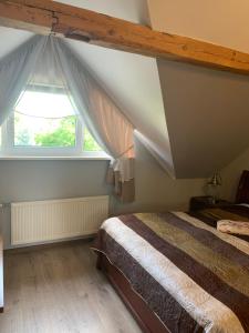 um quarto com uma cama e uma janela em Pūteļkrogs em Tervete