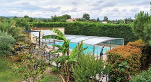 a swimming pool in a garden with a greenhouse at PORT BAS in Brens