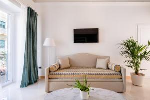 ein Wohnzimmer mit einem Sofa und einem TV in der Unterkunft Pompei Plaza in Pompei
