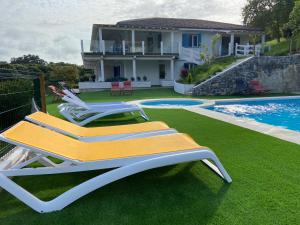 une paire de chaises longues sur une pelouse à côté d'une maison dans l'établissement I LOVE ISLA PLAYA (SOLO FAMILIAS), à Isla