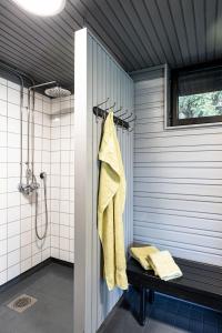 La salle de bains est pourvue d'une douche et d'une serviette jaune. dans l'établissement Guesthouse Solbacka Iittala, à Hämeenlinna